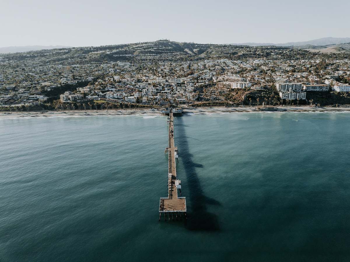  dock near houses surrounded by ocean during daytime 