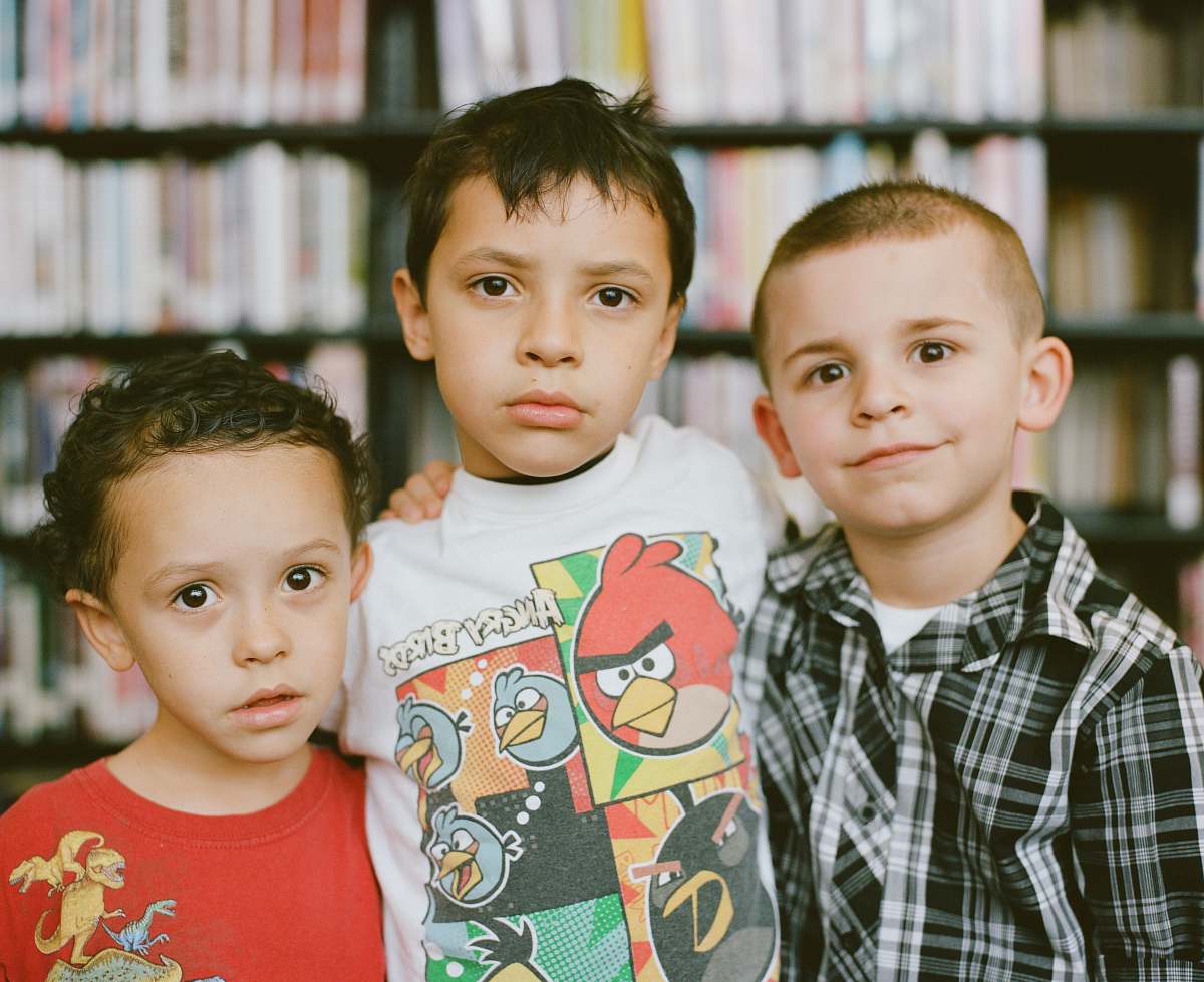 clothing boy in red crew neck shirt beside boy in white and black checkered button up shirt shirt