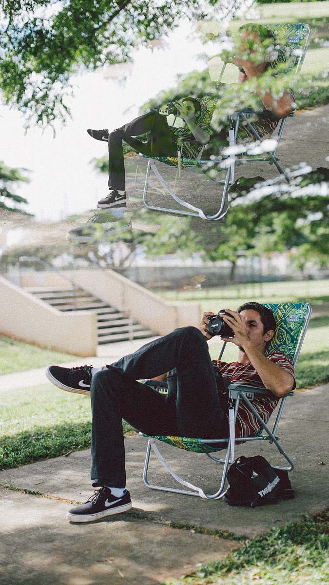 clothing man sitting on folding chair using DSLR camera footwear
