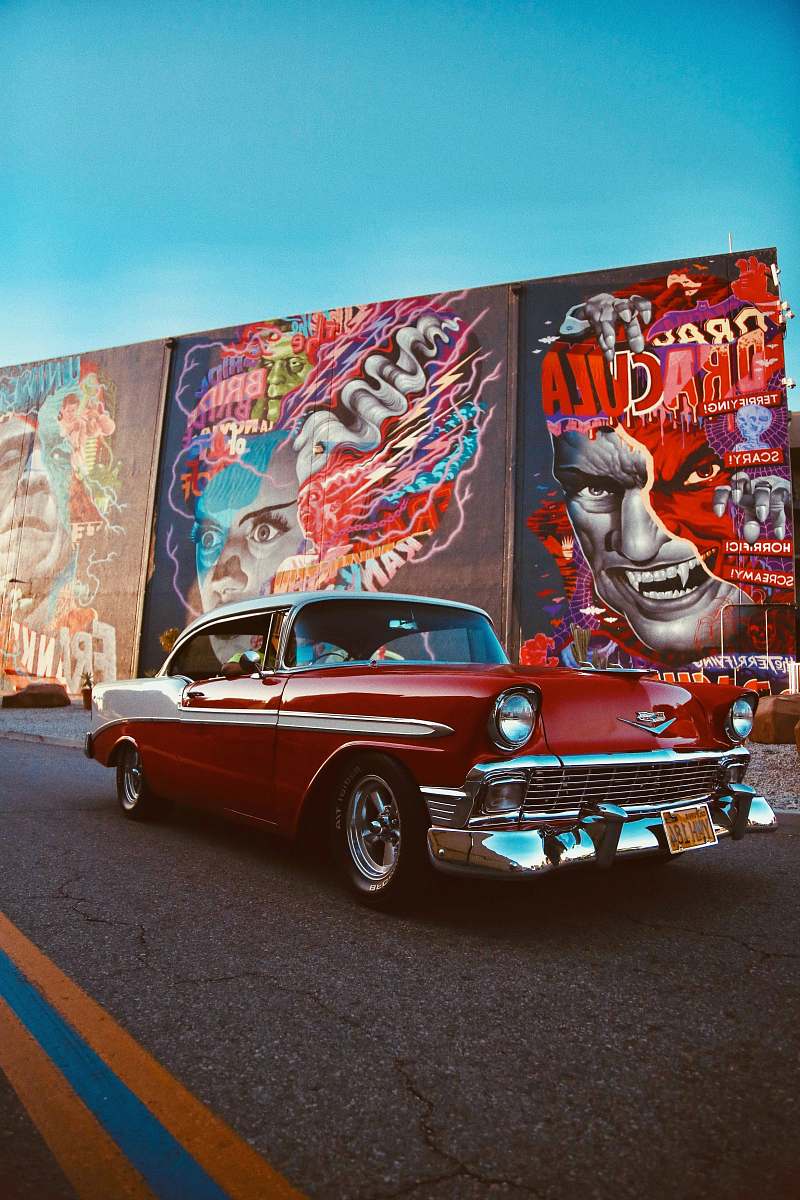 car red classic car parked beside wall with graffiti transportation