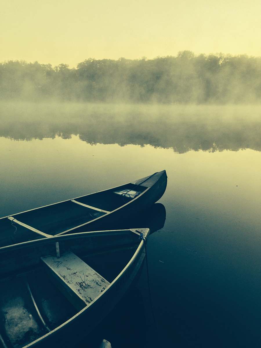 transportation two gray canoes on misty body of water canoe