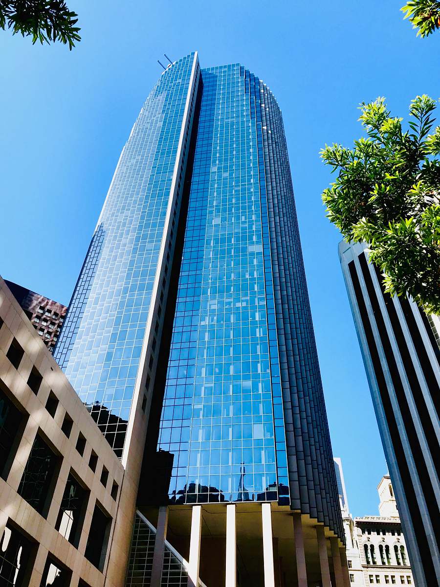 city low angle photo of blue glass curtain building office building