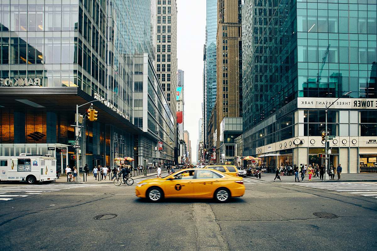 taxi panning photography of tax between buildings cab