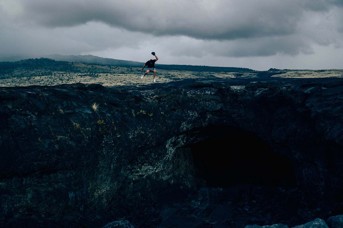 person man standing on rock formation during daytime man