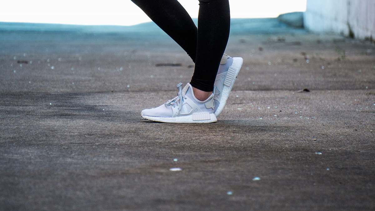 apparel shallow focus photo of person wearing gray running shoes shoe