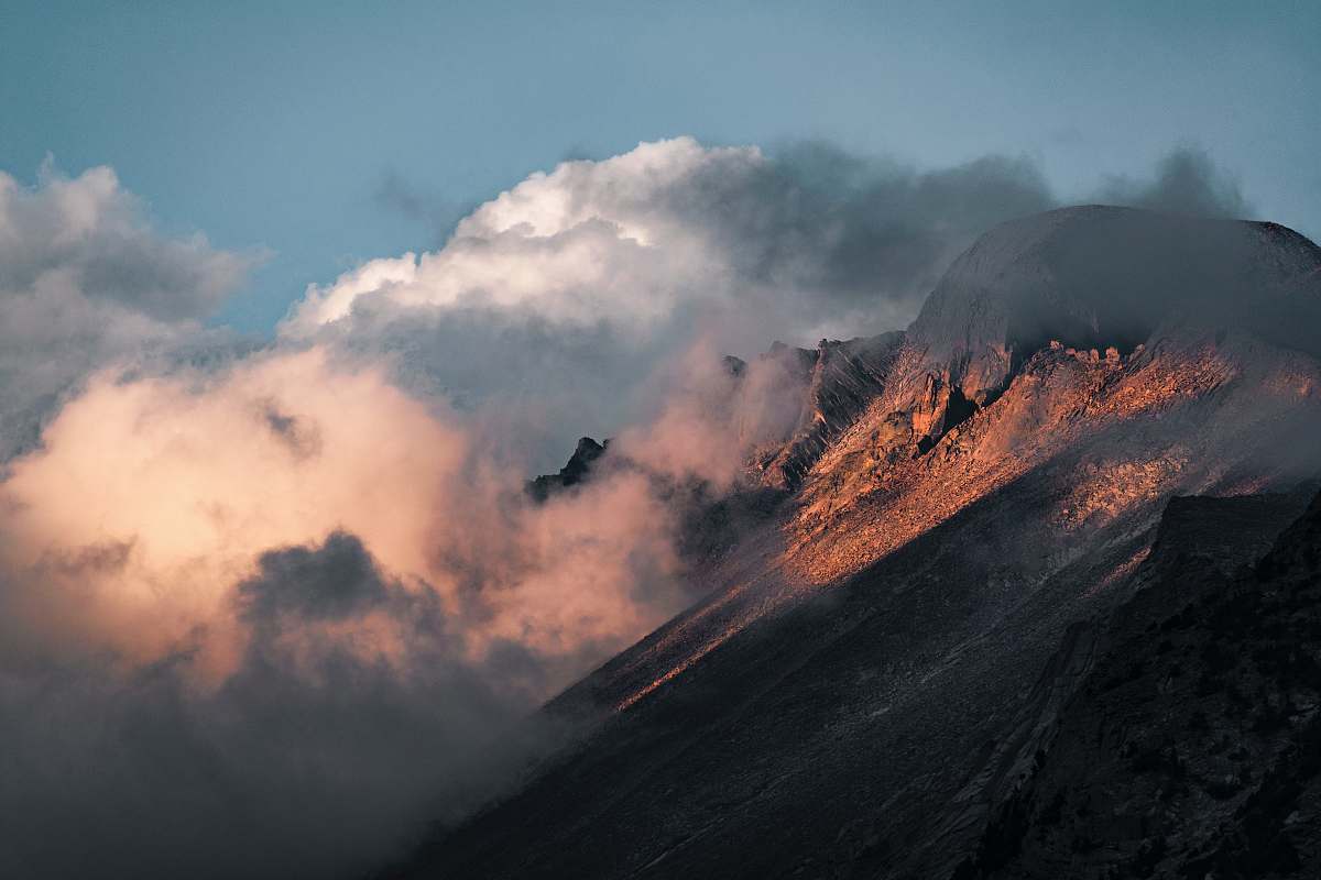 nature clouds enveloping brown rockhill during daytime outdoors