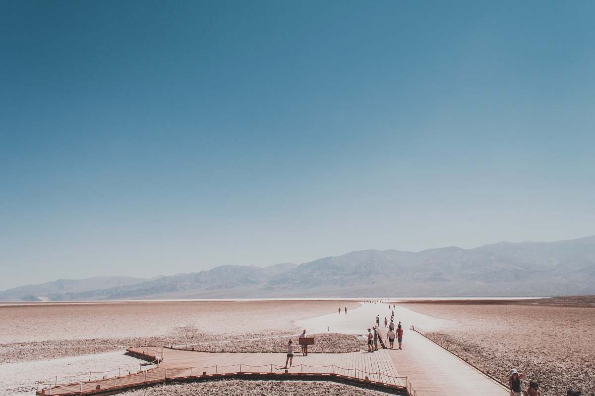 landscape people walking on path towards mountains badwater