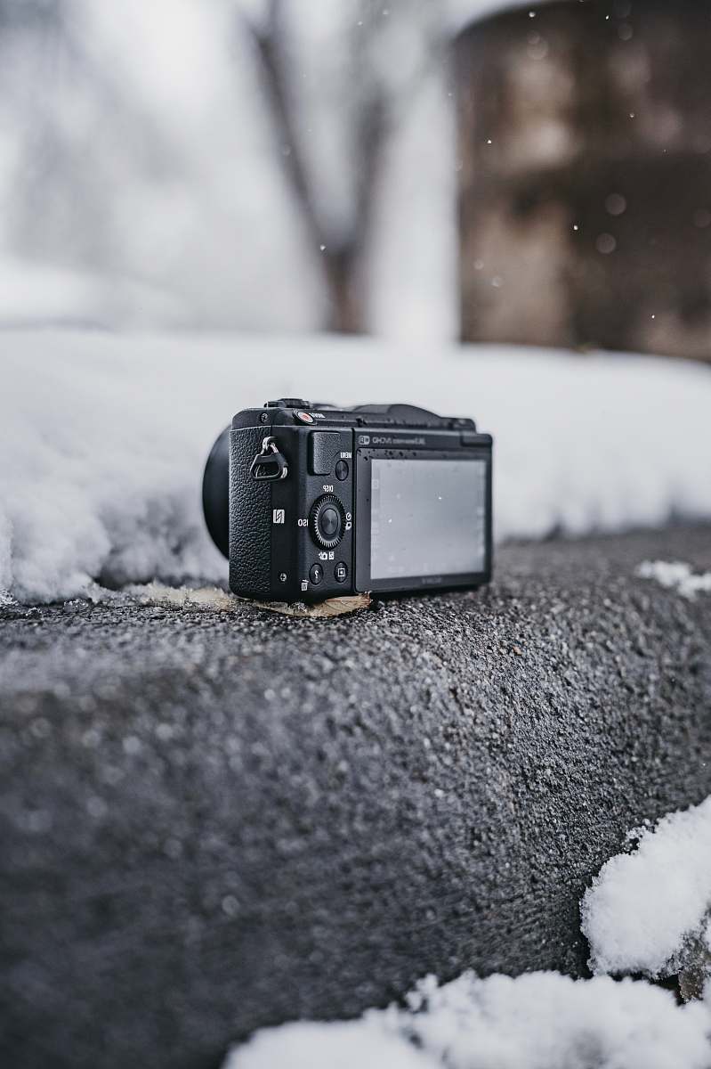 electronics black point-and-shoot camera on gray surface outdoor camera