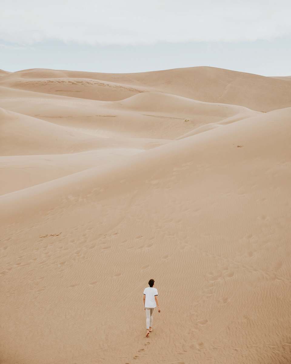 desert person walking on sand dune sand