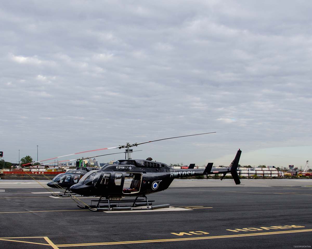 aircraft two black helicopters near on concrete pavement vehicle