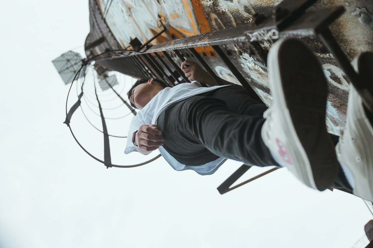 people boy climbing on metal ladder person