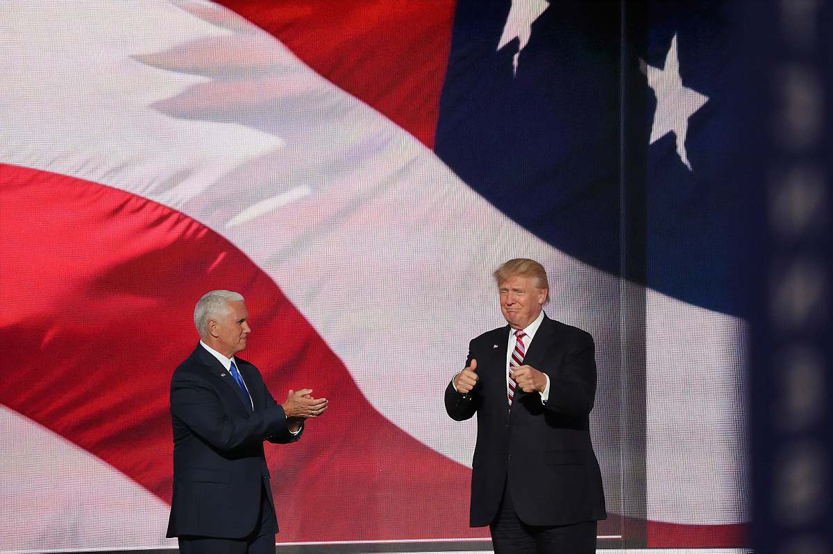 audience Donald Trump beside man in black suit crowd