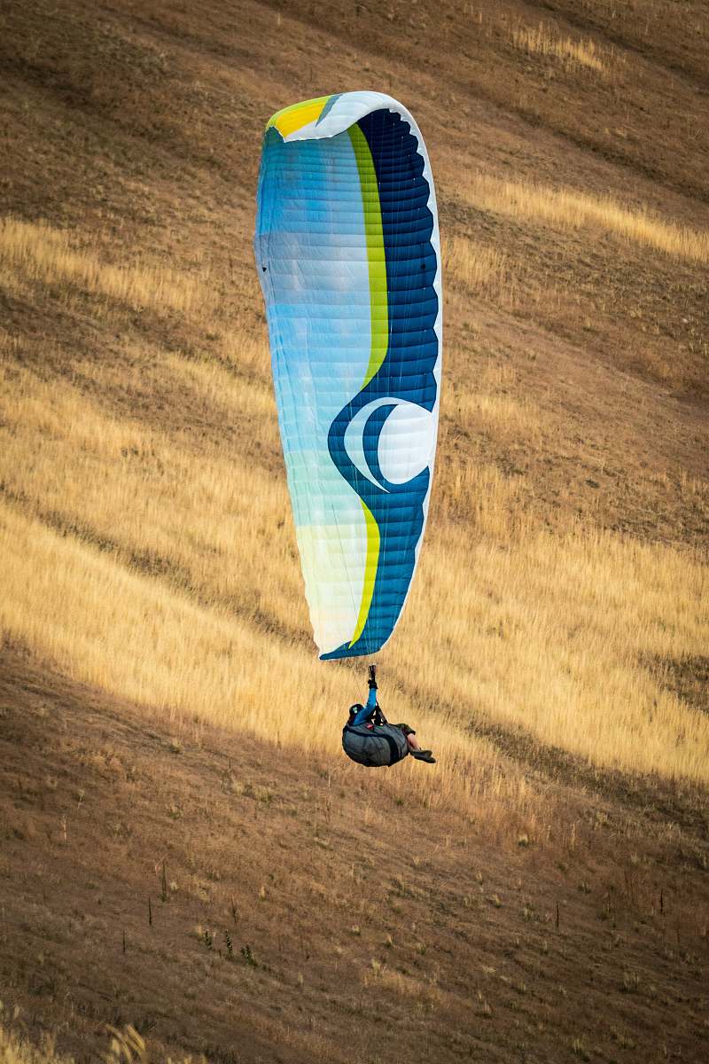 person person hanging on white and blue parachute adventure