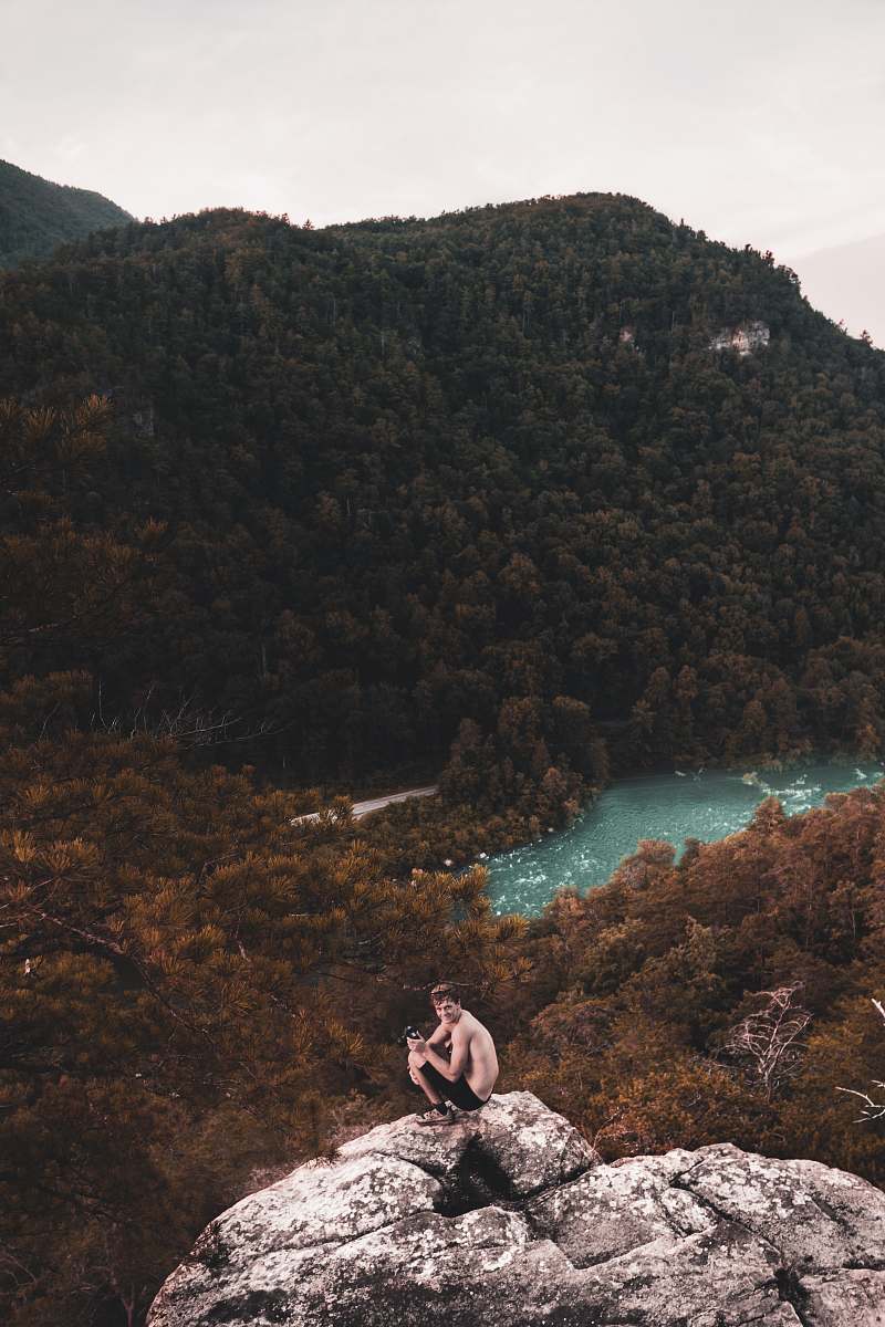 person photo of man sitting on rock formation people