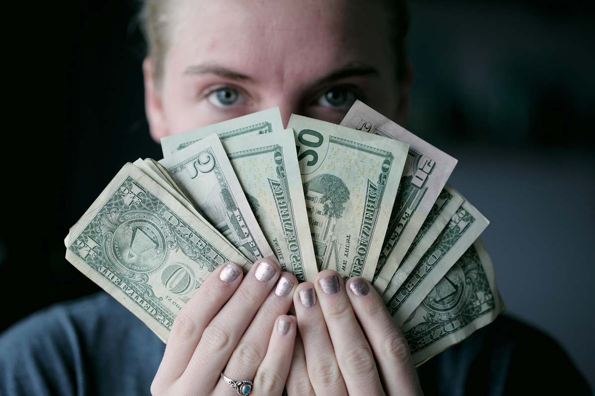 person person holding fan of U.S. dollars banknote people