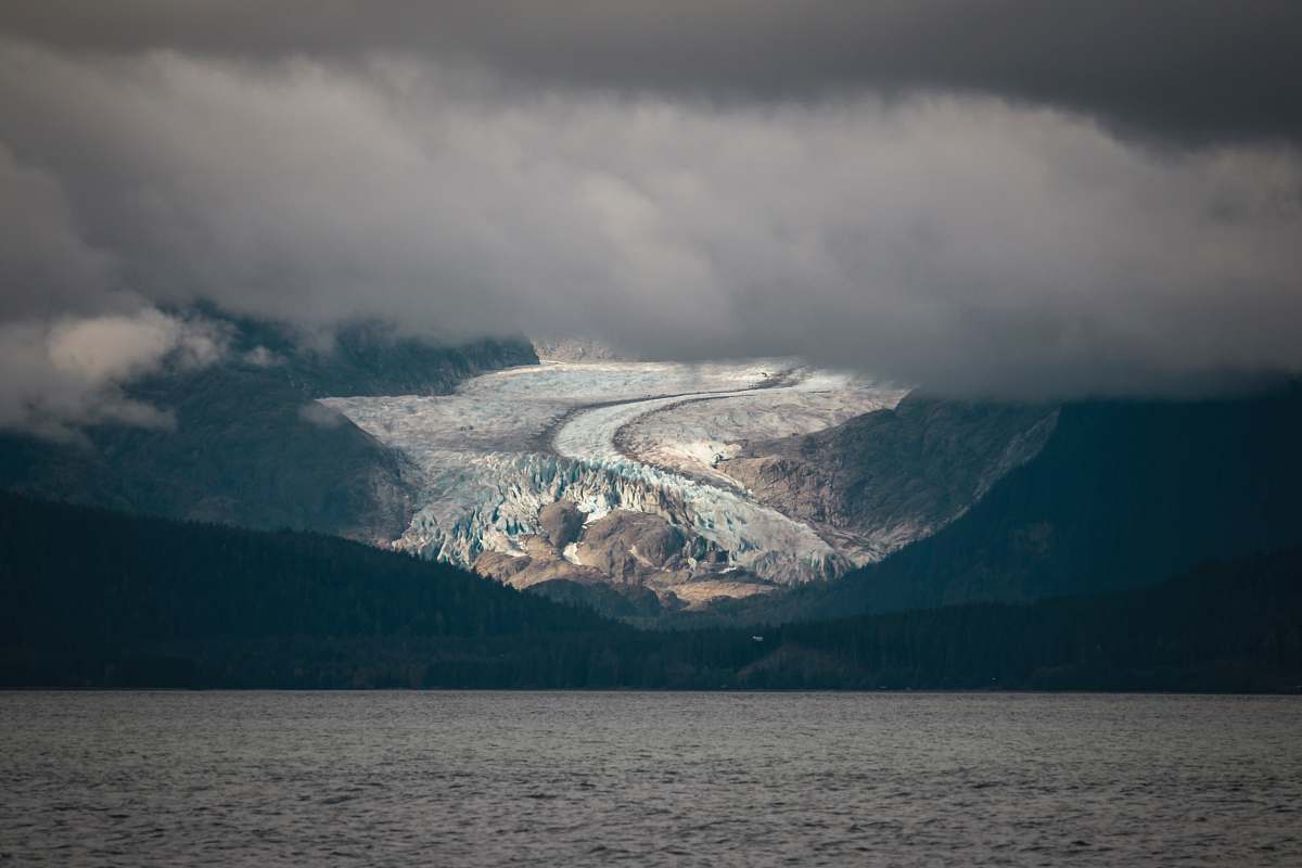 glacier body of water near mountains ice