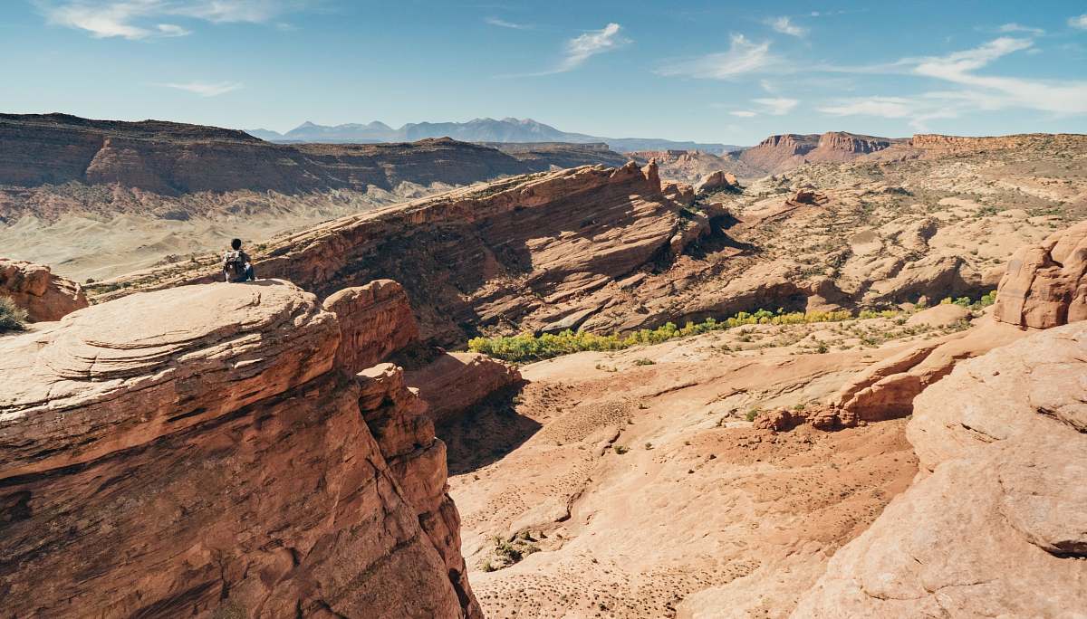 canyon person sitting on brown mountain valley