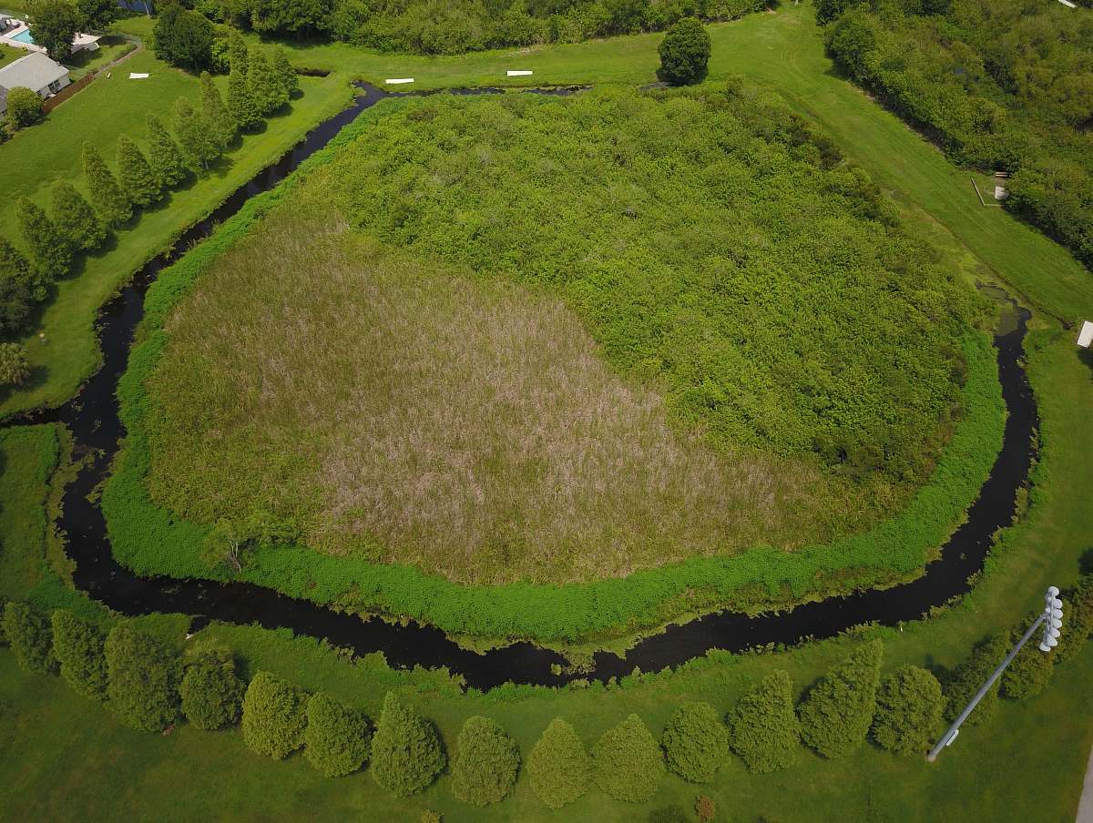 outdoors aerial photography of body of water surrounded by green trees landscape
