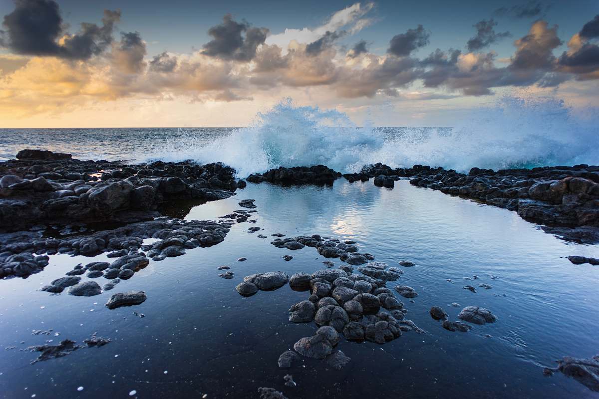 water landscape photography of rocks and barrel wave ocean