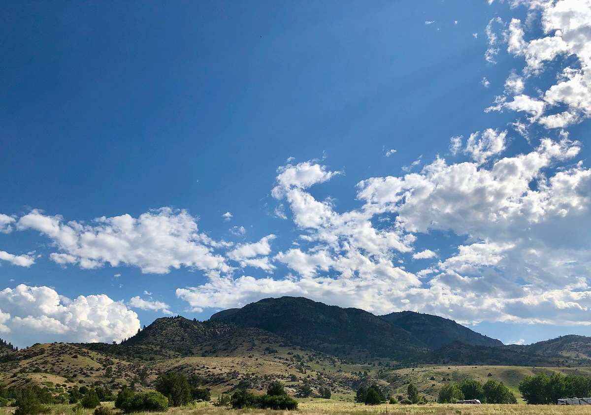outdoors mountain under white clouds and blue sky during daytime azure sky