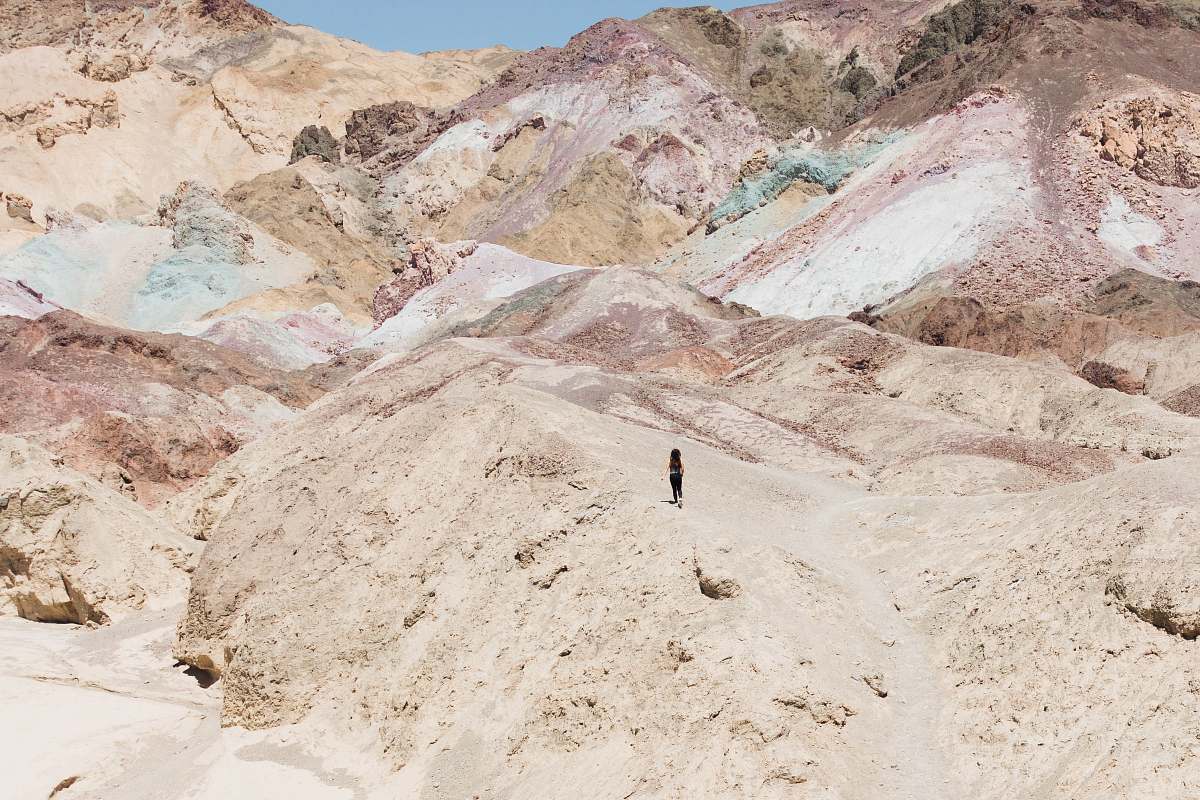 outdoors person standing on rocky mountain during daytime mountain