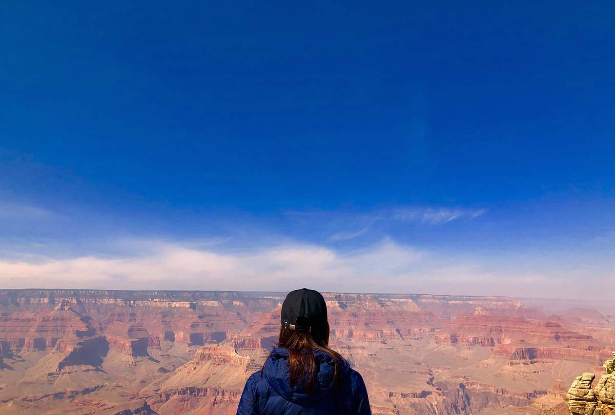 mountain woman wearing blue hoodie standing in front of mountain view outdoors