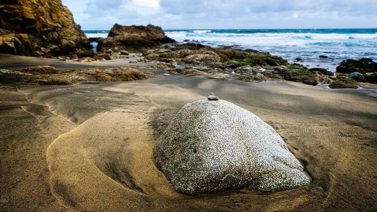 beach gray rock on shore beside sea at daytime sea