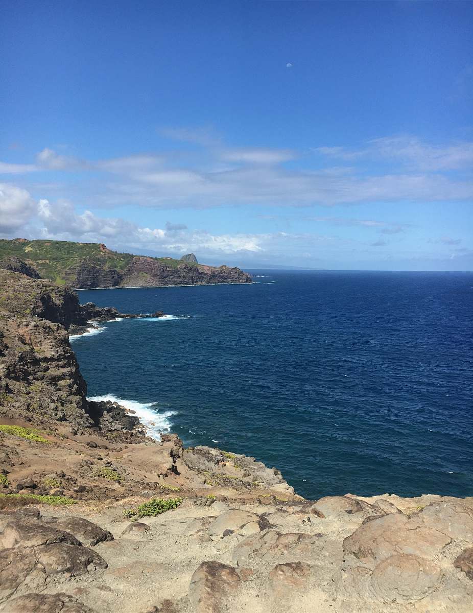 land brown rock cliff beside ocean promontory