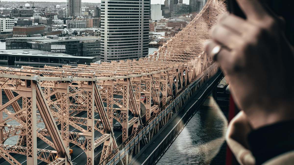 person black and brown concrete bridge near city buildings human