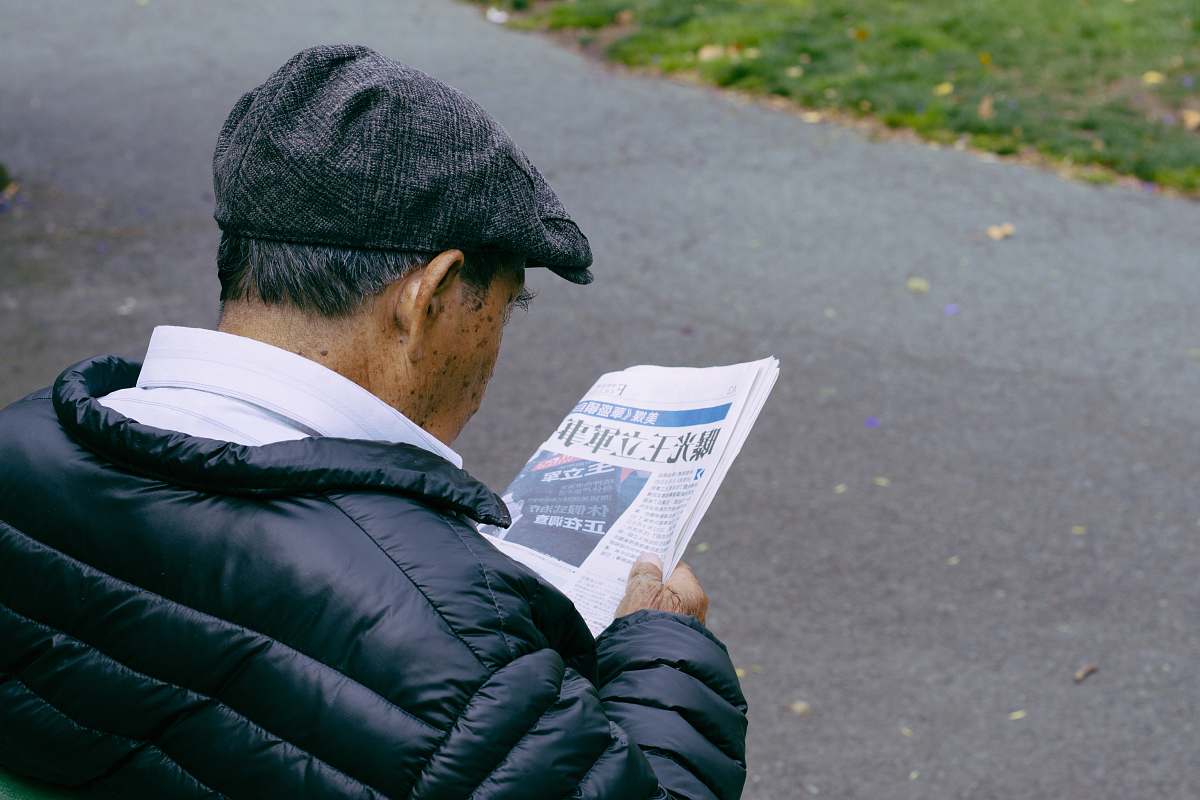 person man reading newspaper human