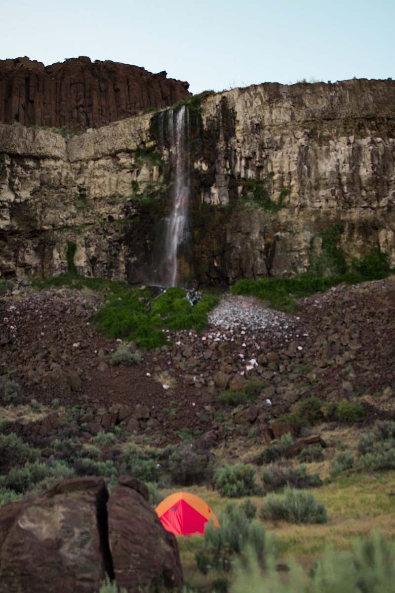 person waterfalls on rock formation at daytime human