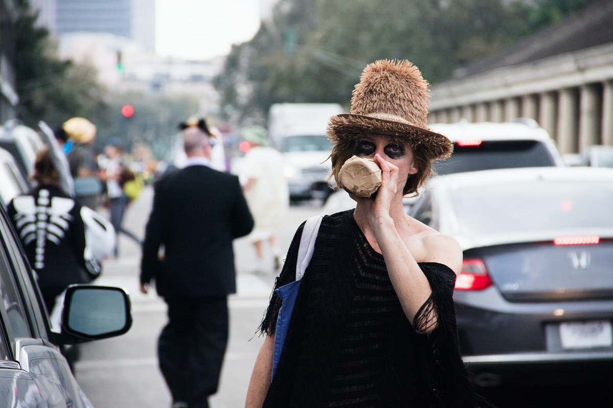 person woman drinking from bottle while standing near traffic human