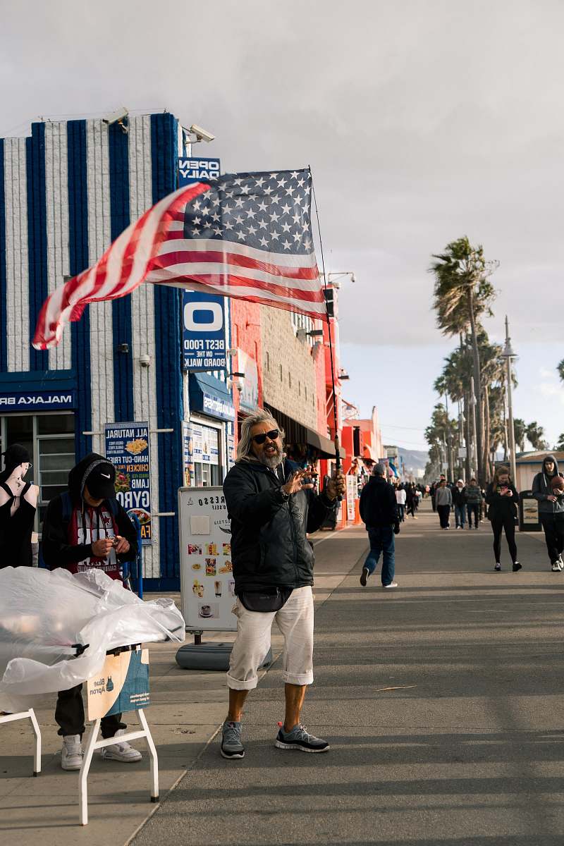 building man standing near building and flag of America people