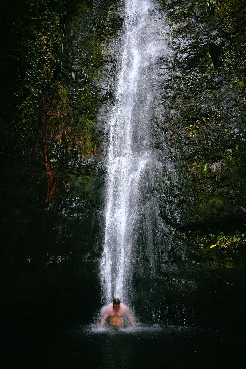 human man swimming under waterfalls people