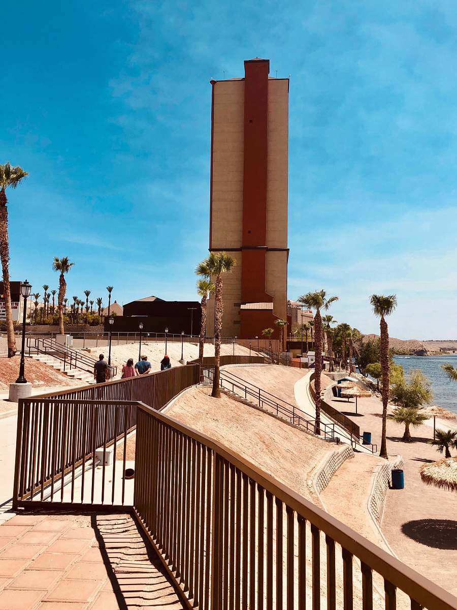 human people walking on beach during daytime railing