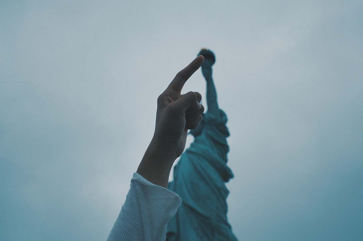 human person's pointing finger pointing statue of liberty torch people