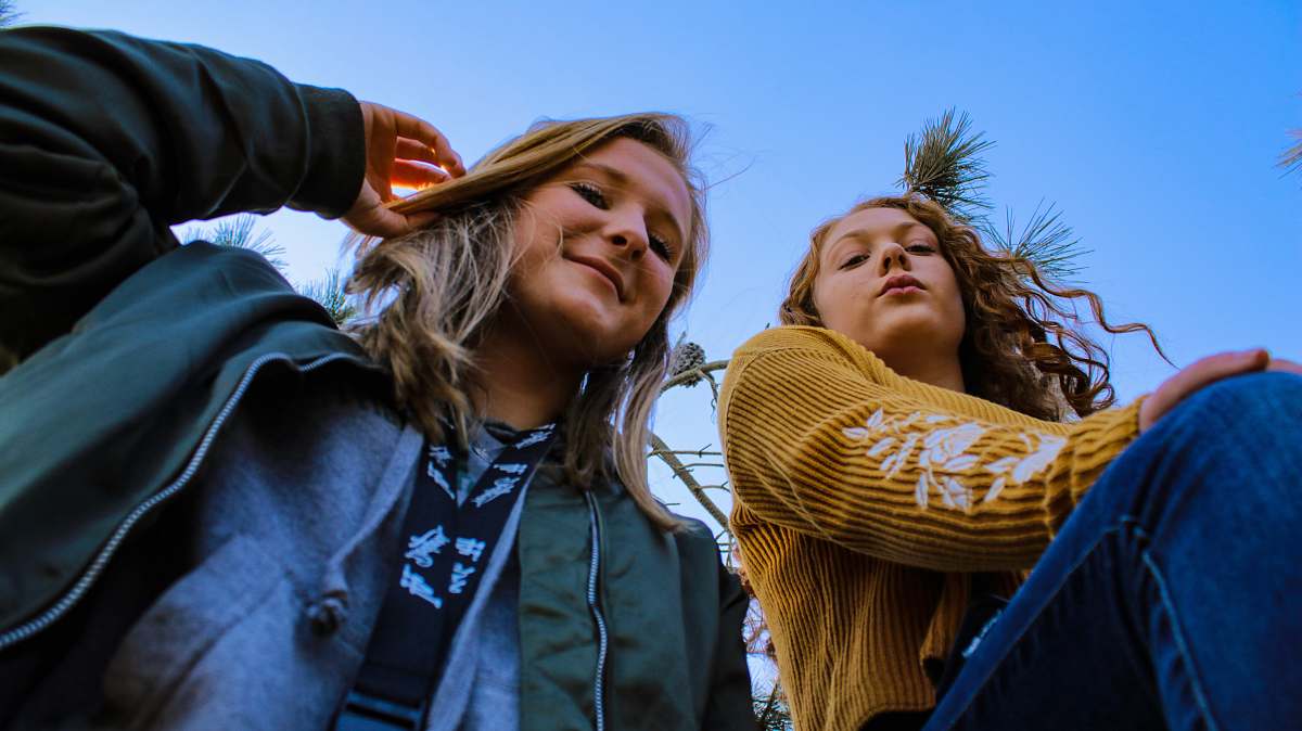 people two women posing and looking down at the camera human