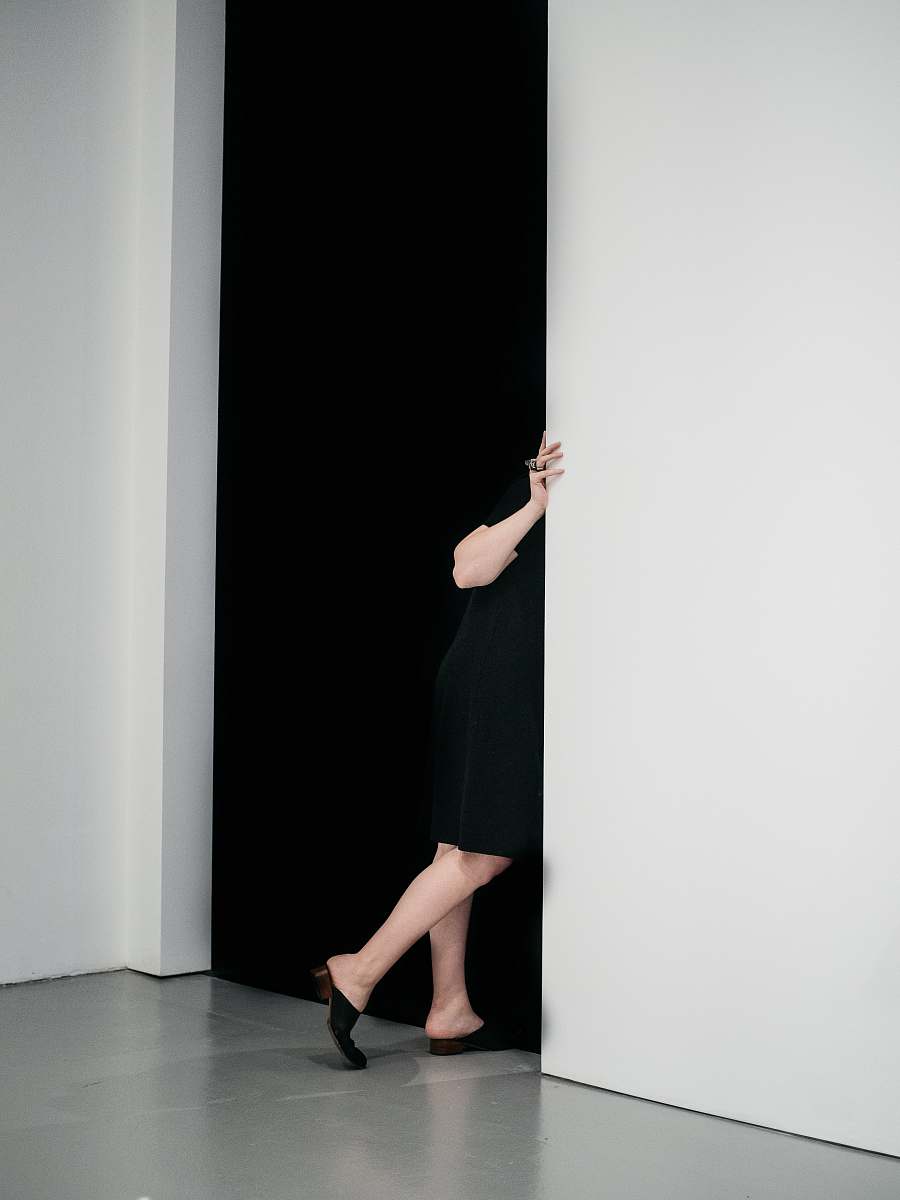 human woman standing sneaking on door inside white painted room people