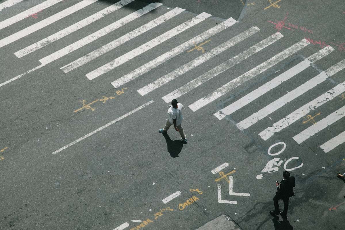 person two man walking on pedestrian lane during daytime human