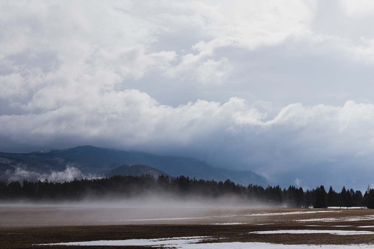 cloud trees near mountain under white clouds during daytime weather