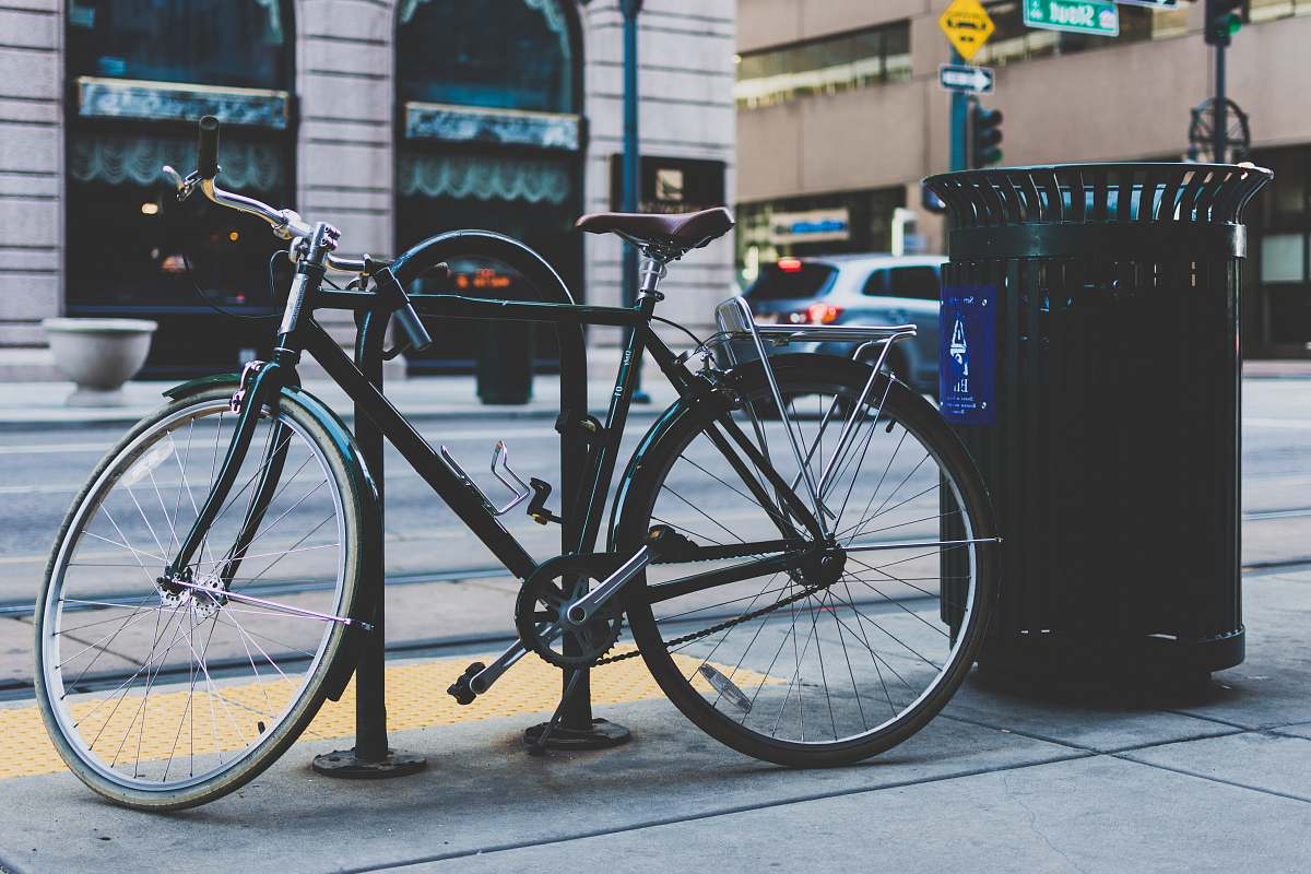 bicycle black rigid mountain bicycle parked next to black trash bin bike