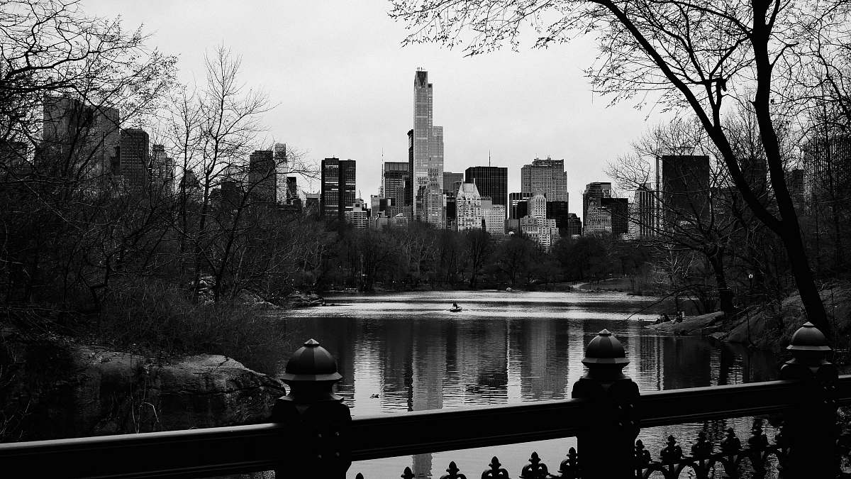 black-and-white grayscale photo of buildings near ocean during daytime railing