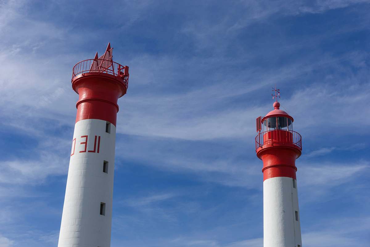 Capture the essence of maritime beauty with this striking image of two iconic red-and-white lighthouses standing proudly against a vibrant blue sky. Perfect for travel blogs, nautical-themed projects, or coastal dcor, this photograph showcases the timeless allure of these guiding lights and their serene surroundings. Ideal for both personal and commercial use, it brings a touch of coastal charm to any visual narrative.