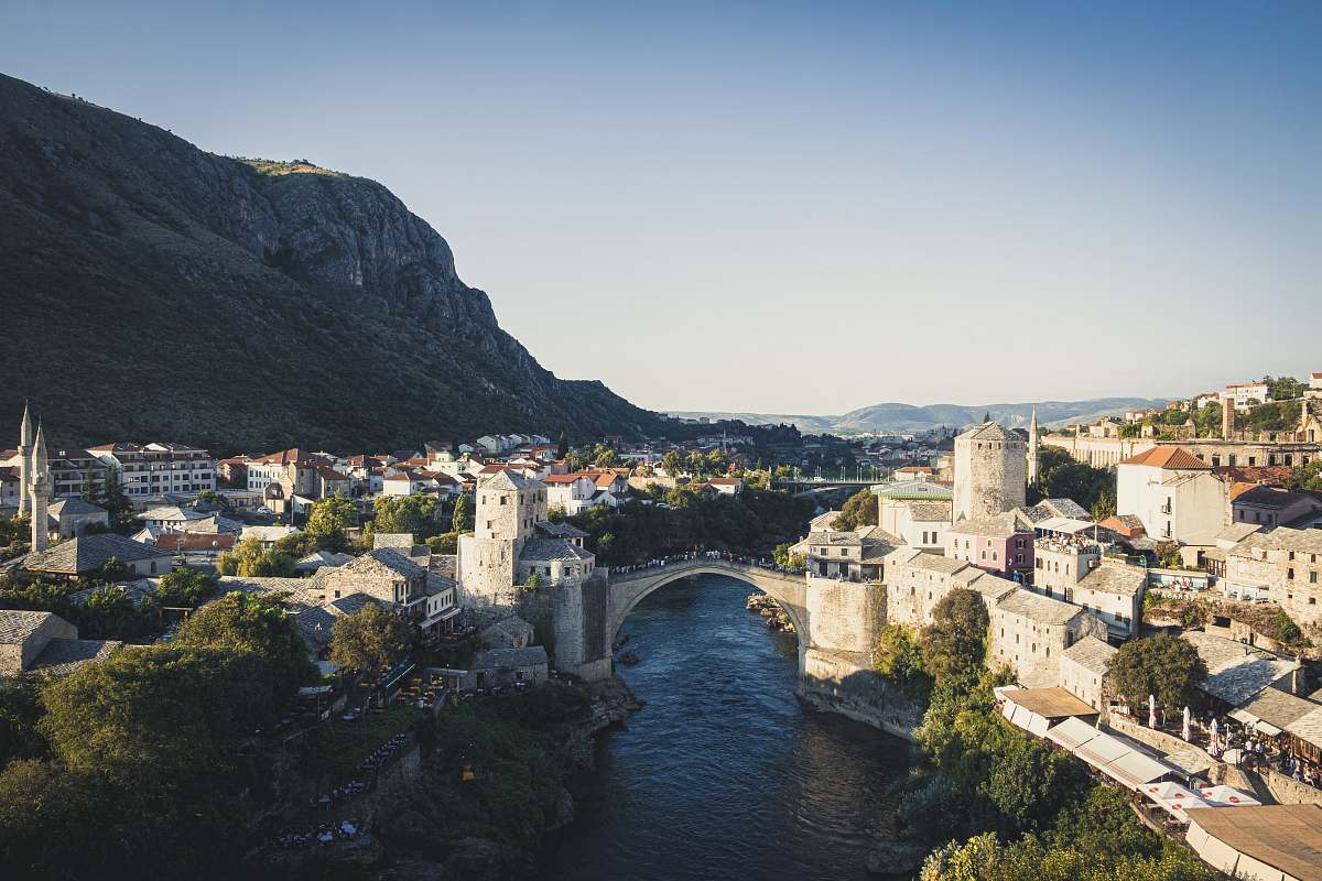 building aerial photography of houses and buildings near bridge viewing mountain during daytime castle