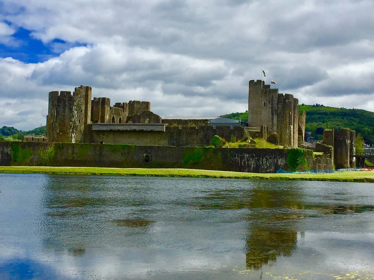 building ancient castle facing body of water under cloudy sky moat