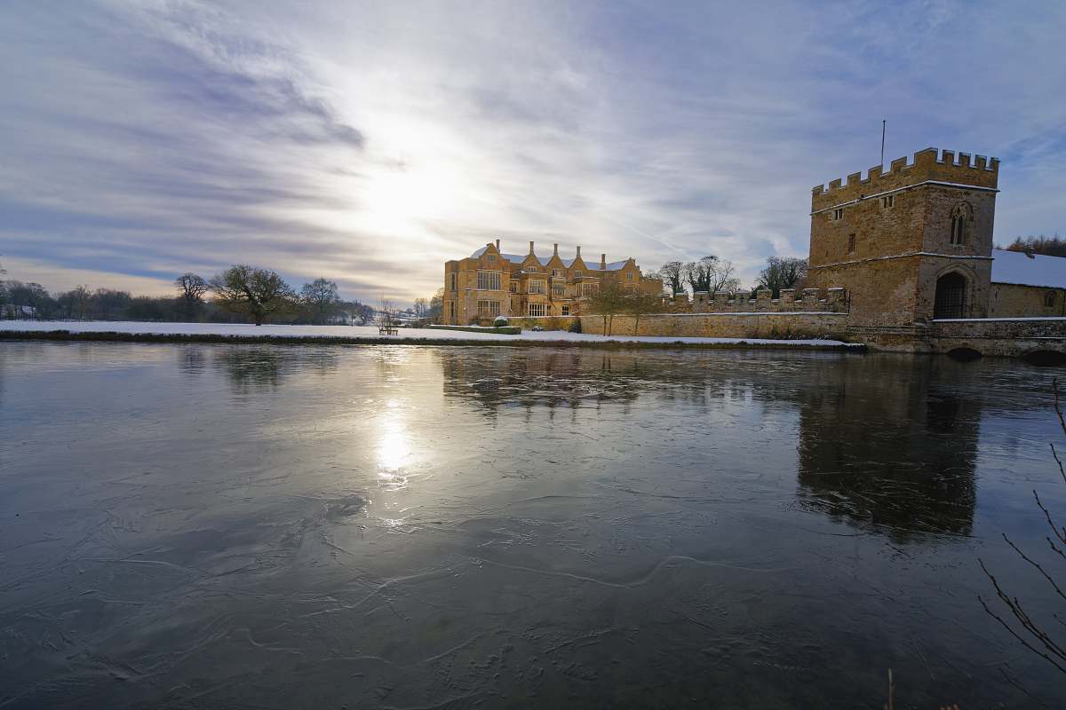 building beige castle surrounded by body of water during daytime castle
