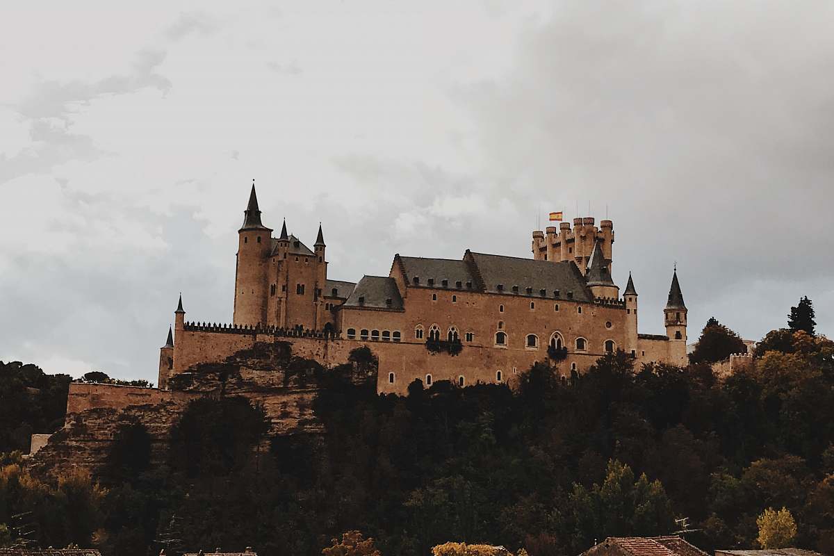 building beige concrete castle on top of hill under white skies castle