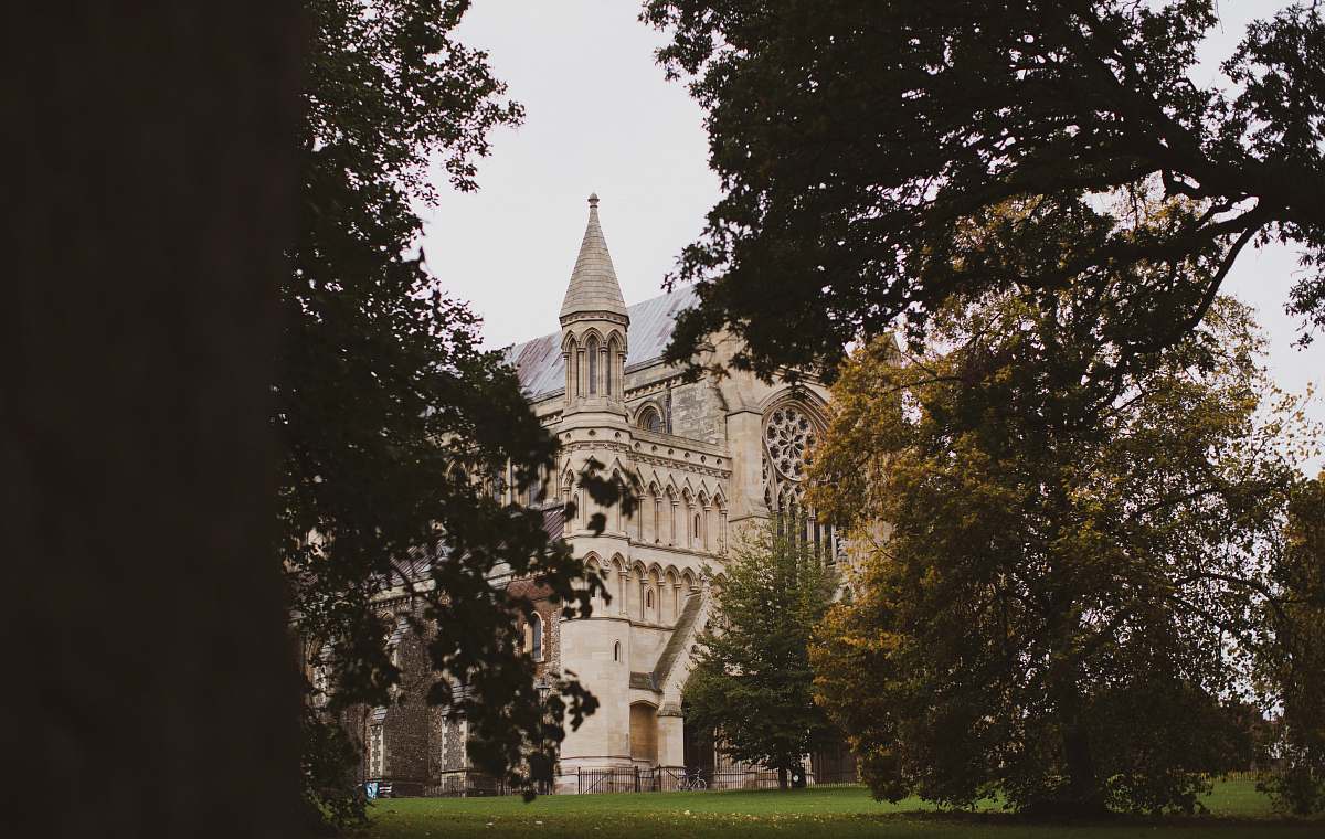 building beige house surrounded by tress spire