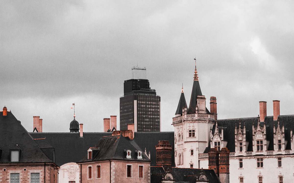 building black and brown building under cloudy sky spire