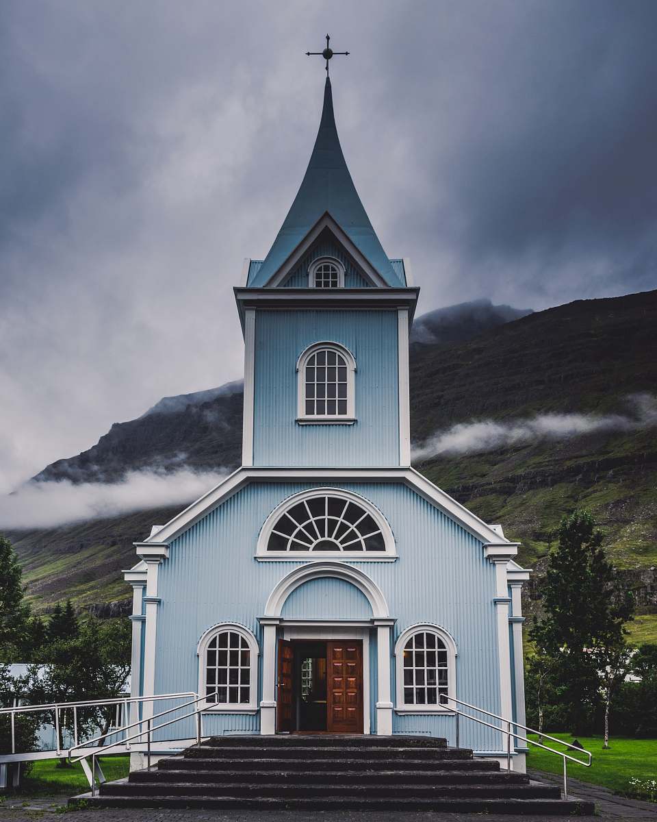 building blue and white wooden church during daytime spire